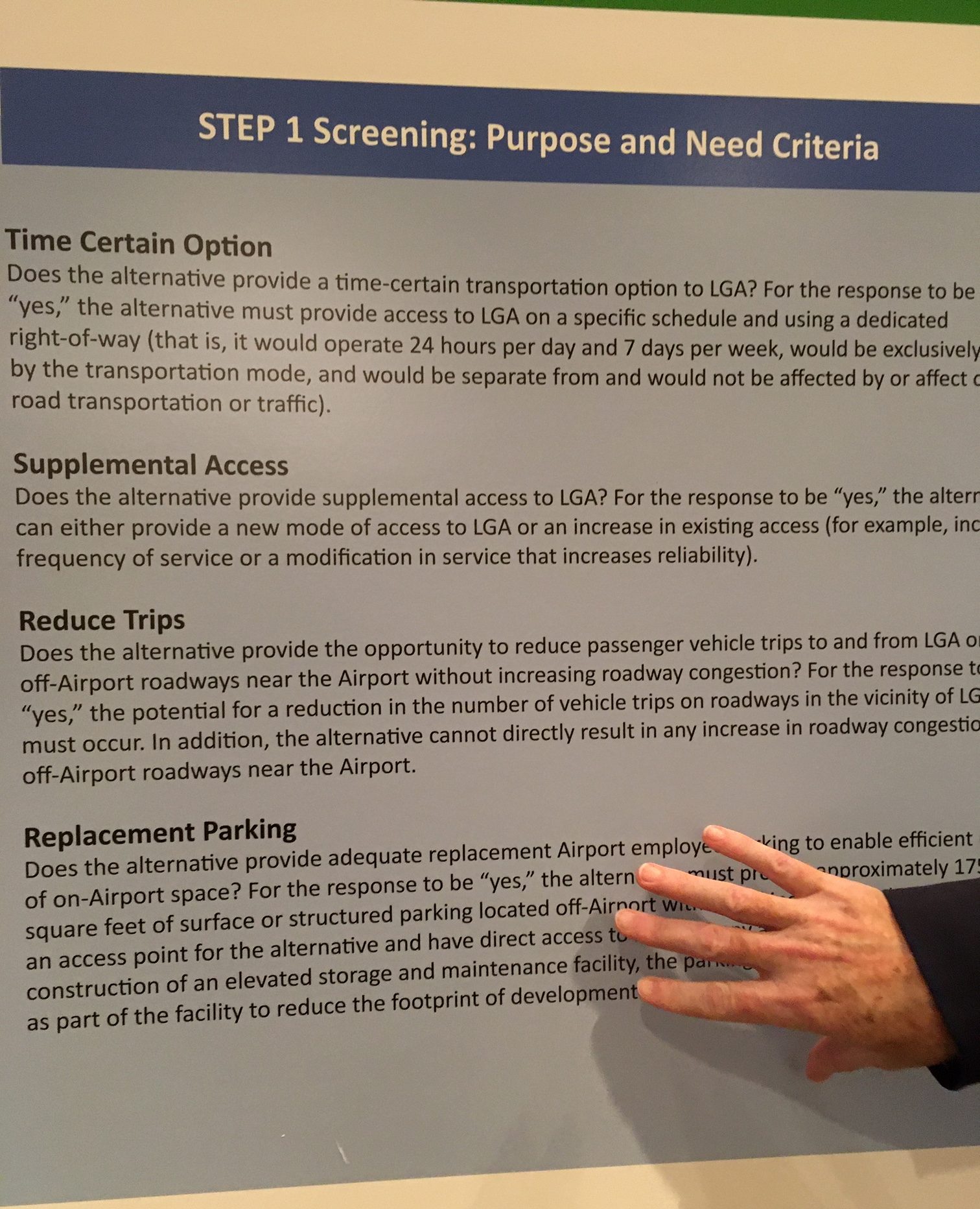Read the fine print: This poster from the LGA Access open house points out the real reason for the Willets Point location of the AirTrain station — to provide parking. Photo: Eve Kessler